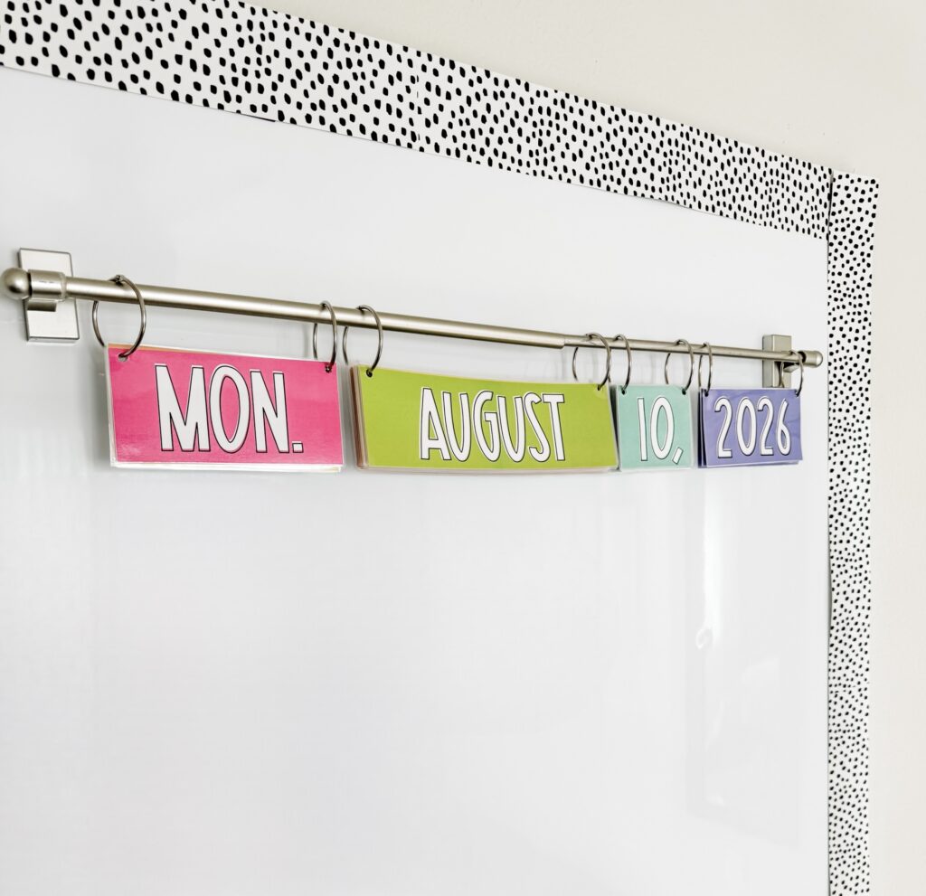 This image shows a classroom flip calendar hanging on a magnetic curtain rod on a magnetic whiteboard.