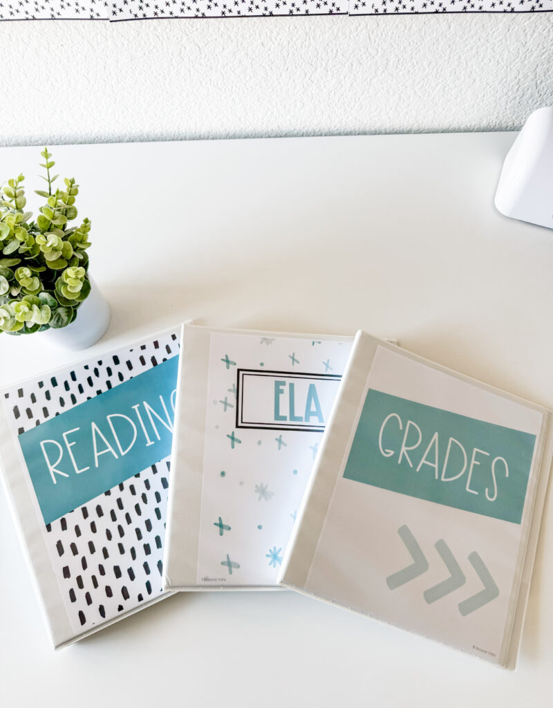This image shows three binders with simple and blue binder covers. One binder cover says Reading. Another says ELA. The last one says Grades. They all have three different styles. 