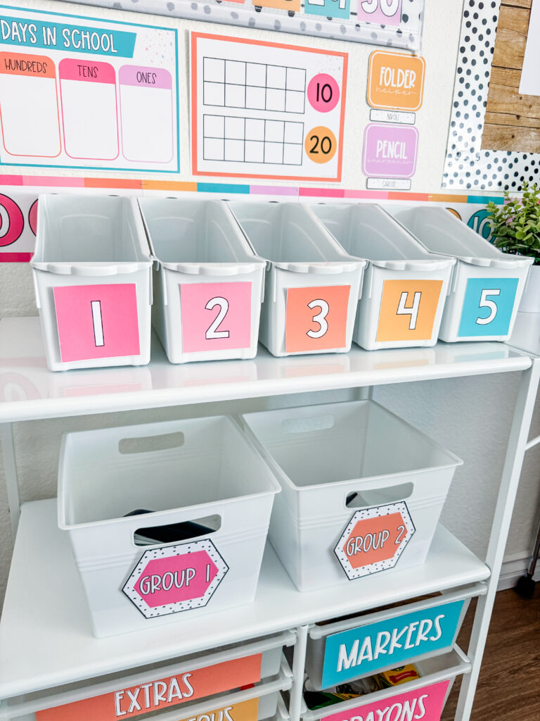 This image shows book bins with bright, pastel-colored labels showing student numbers.
