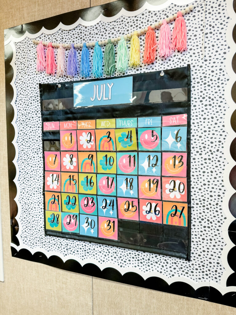 This image shows a bright, tropical calendar in a pocket chart.