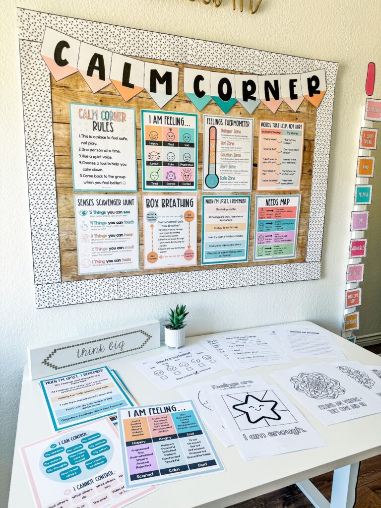 This image shows a calm down corner in a classroom with a bulletin board and table filled with calming resources.