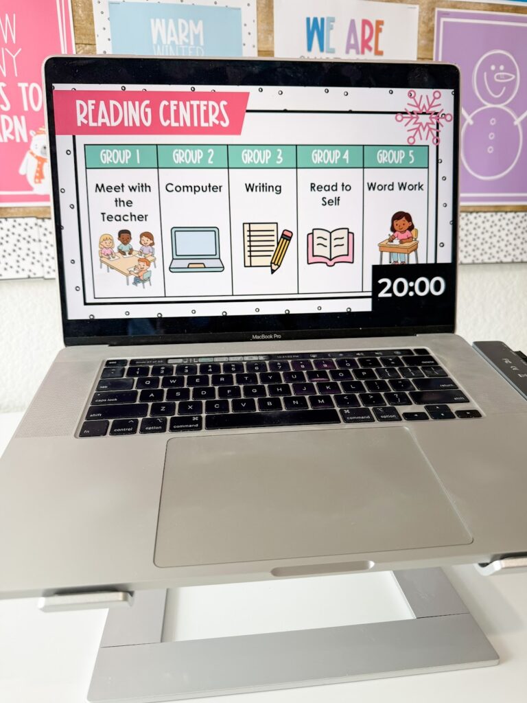 This image shows a centers slide with 5 different group activities listed an a 20 minute timer in the bottom corner. Each group's section has the words for the task and a small image.