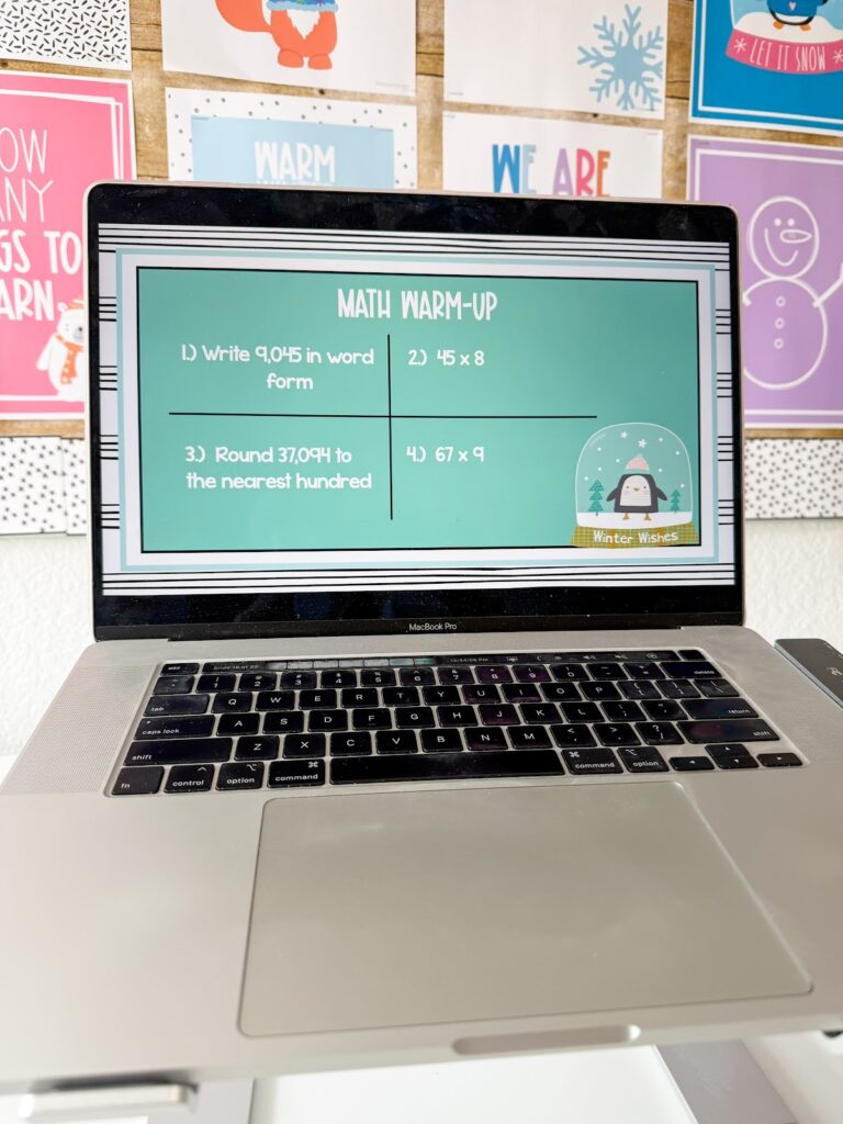 This image shows a math warmup template slide decorated with winter items.