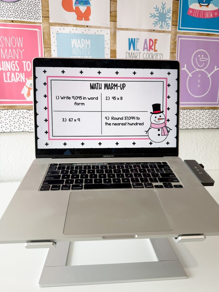 This image shows a math warmup template slide decorated with winter items.