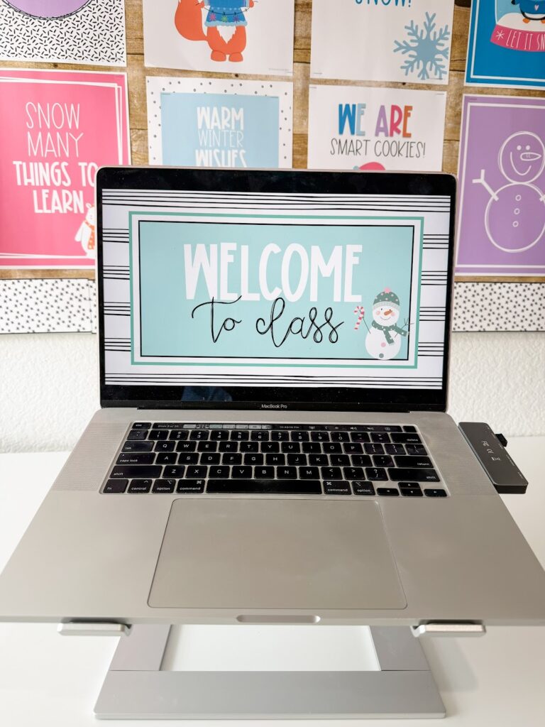 This image shows a computer with a slide that reads "Welcome to Class" and has a festive snowman in the corner.