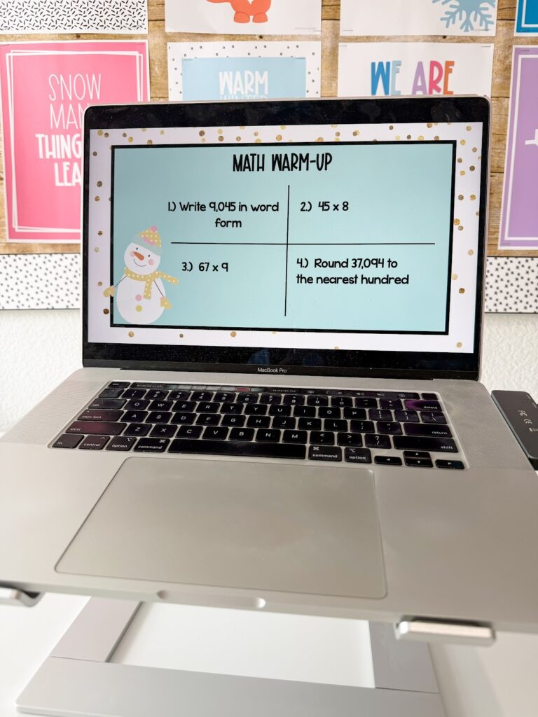 This image shows a math warmup template slide decorated with winter items.