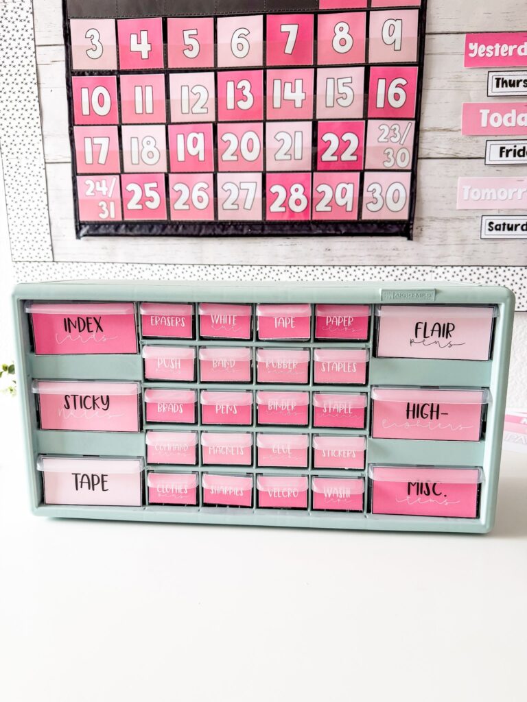 This image shows a closeup of a teacher toolbox decorated with editable labels from the simple + pink classroom decor bundle. All of the labels have a solid shade of pink as the background with the word for the item included across the top. 