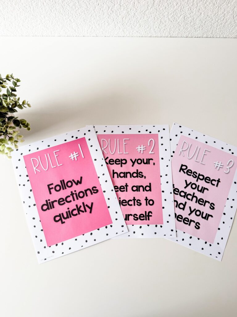 This image shows three different classroom rules posters included in the simple + pink classroom decor bundle. Each poster is mostly a rectangle that is a solid shade of pink with a white and black polka dot border around each one. 