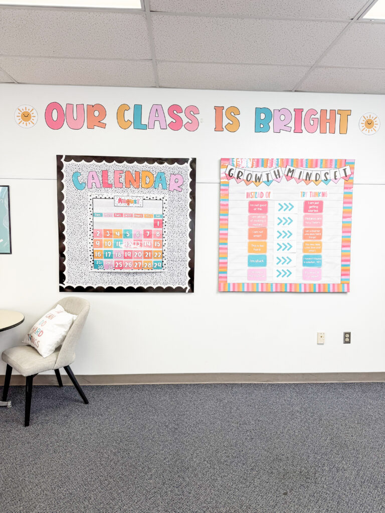 This image shows a wall with two DIY bulletin boards hanging up. One is a calendar display. The other is a growth mindset display. Above both of them, in giant letters, is the phrase, "Our class is bright".
