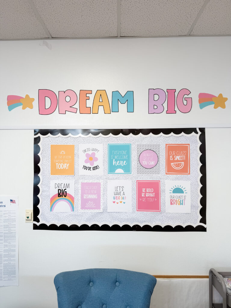 This image shows a closeup of a DIY bulletin board with inspirational posters hanging on it. Above the bulletin board is the phrase "Dream Big" in massive bubble letters.