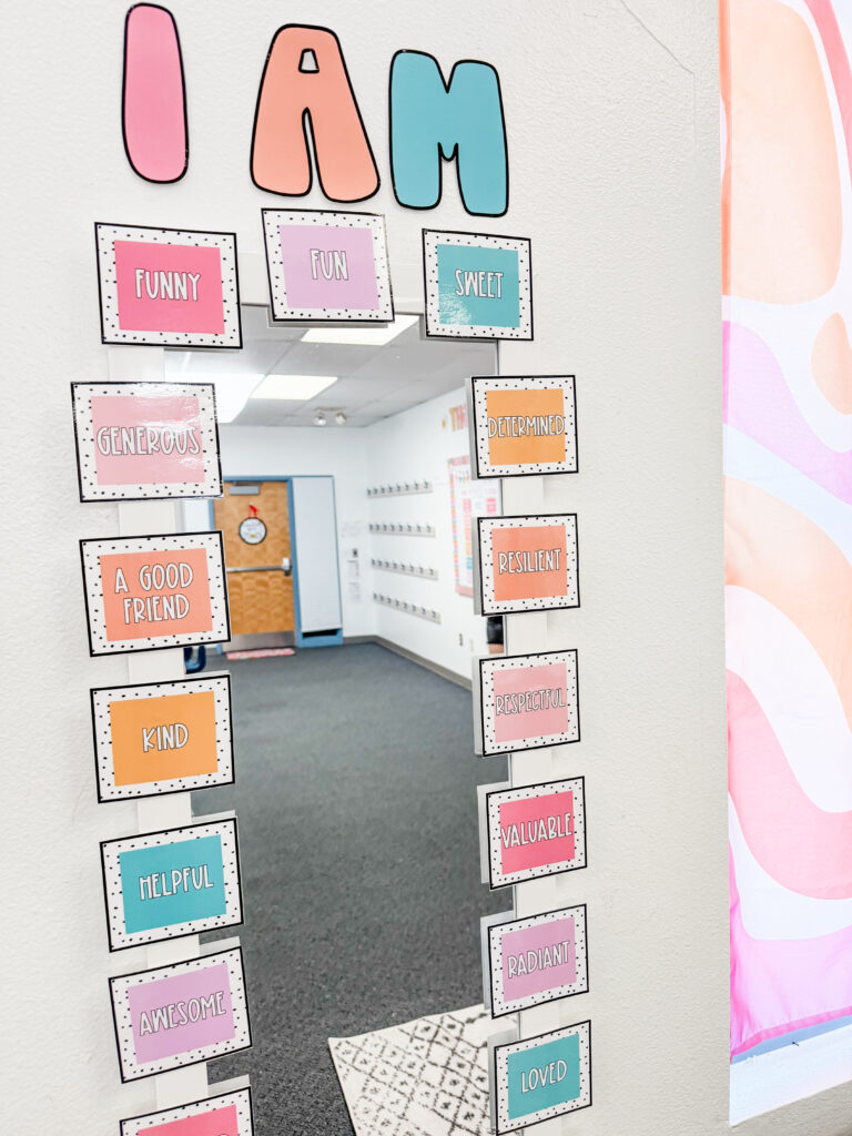 This image shows an affirmation station in a 4th grade math classroom that includes a white mirror with pastel colored cards including one word affirmations all the way around the mirror.