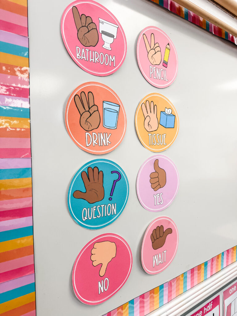 This image shows a close-up of the hand signal posters on the whiteboard in this classroom.