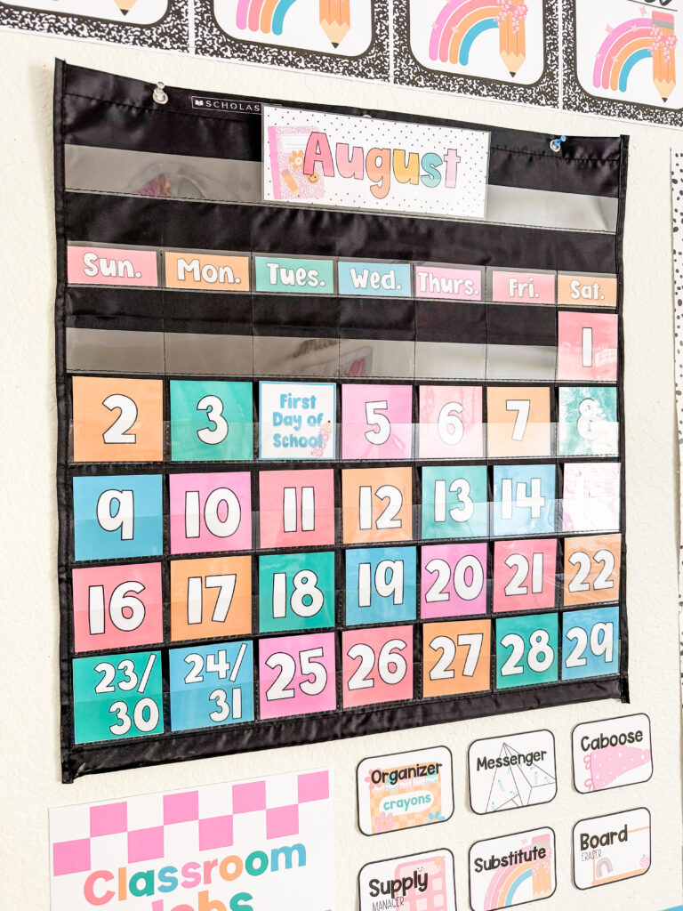 This image shows a pastel classroom calendar in a black pocket chart included in the school edit decor bundle.