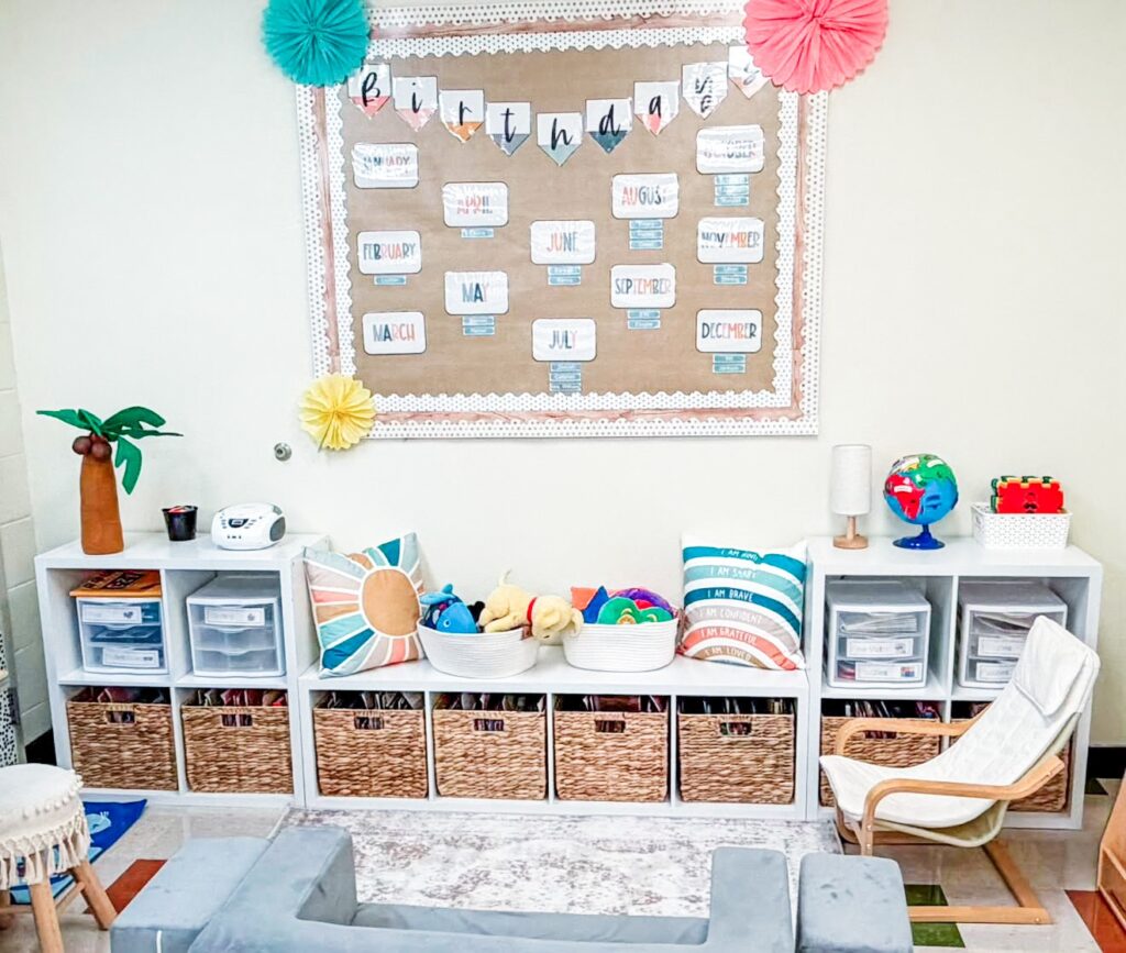 This image shows an overview of a reading area in a pk classroom. There is a low, one-shelf cube organizer surrounded by two-by-two cube organizers, creating a bench seat. There are pillows, a cozy chair, and baskets holding picture books.