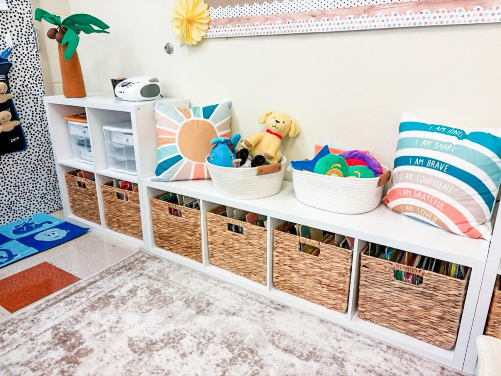 This image is a close-up of the pk classroom reading nook. There are baskets filled with stuffed animals and other soft pillows to be used as reading buddies in this area to make reading fun. 