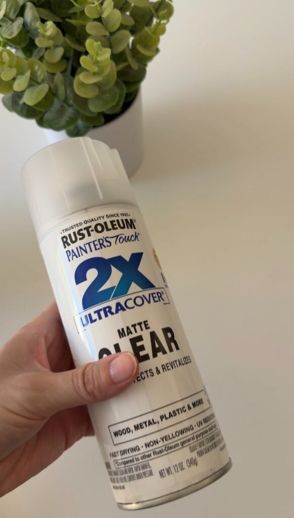 This image shows a teacher holding a can of Matte Clear spray that helps get rid of the glare from lamination.